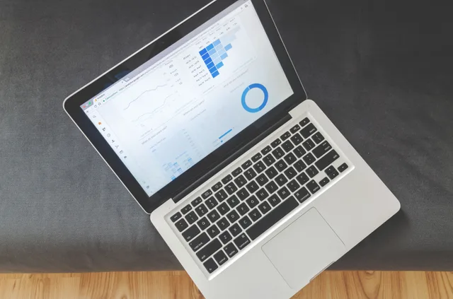 Overhead view of a laptop showing data visualizations and charts on its screen. A buyer's guide to twelve categories of CRM strategy tools
