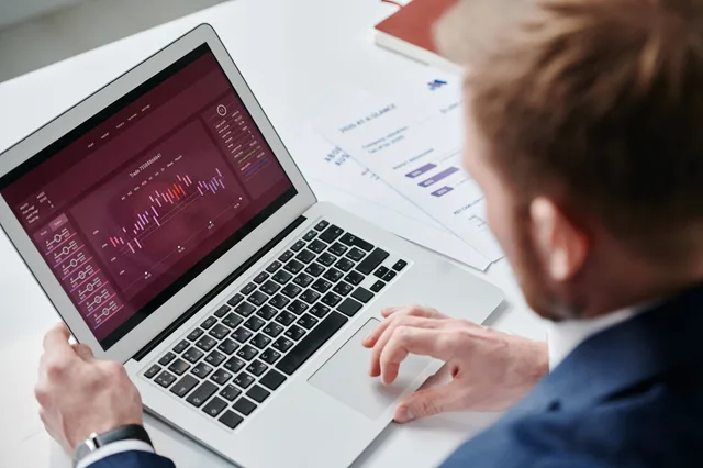 Businessman reviewing data analytics dashboard on laptop in bright office. 5 answers on marketing data governance tools, in order