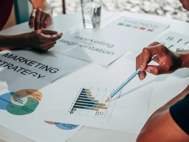 Team working on marketing strategy using data charts and papers in an office meeting. Marketing resource management mistakes to watch for