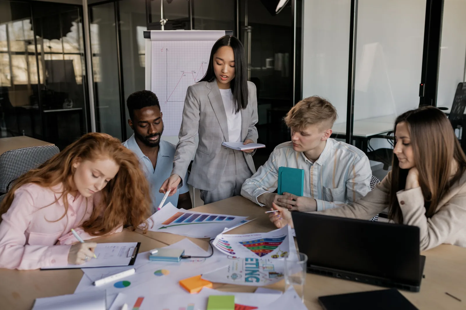 Colleagues discussing business strategy in a modern office setting with charts and notes. Marketing workflow management examples worth copying, and why